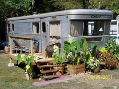 an rv is parked next to some plants