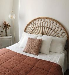 a bed with white and brown sheets, pillows and blankets on top of it in a bedroom