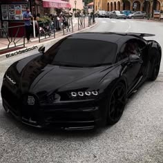 a black bugatti is parked on the street