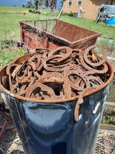 an old rusty trash can sitting in the middle of a yard