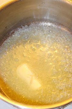 a metal bowl filled with liquid on top of a stove