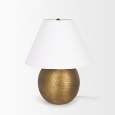 a gold lamp with a white shade on the top and bottom, against a white background