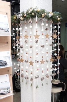 a white curtain decorated with gold stars and pineconis hanging from it's side