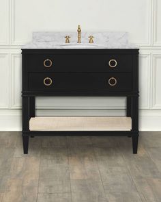 a bathroom vanity with marble top and gold faucets on the sink, against a white wall