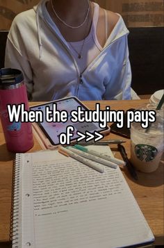 a woman sitting at a table with a notebook and pen in front of her, which reads when the studying pays off > >