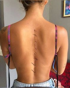 the back of a woman's body with writing on her upper and lower back