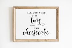 a framed sign that says all you need is love and cheesecake on the wall