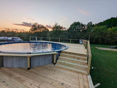 an above ground pool with steps leading up to it and a hot tub in the middle