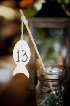 a table with a glass jar and wooden stick on it that says 13 in the center