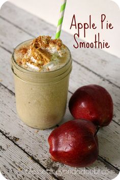 an apple pie smoothie in a mason jar next to two apples