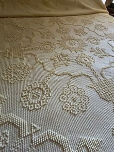 the bed is made up with white crocheted bedspread