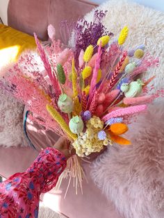 a bouquet of flowers sitting on top of a pink couch