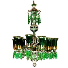 a chandelier with green glass shades hanging from it's centerpieces