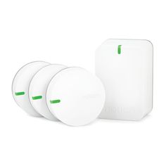 three white wireless devices sitting next to each other on a white surface with green accents