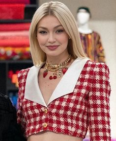 a woman in a red and white top is standing next to a mannequin