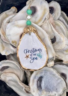 a christmas ornament hanging from a pile of oysters with pearls on it