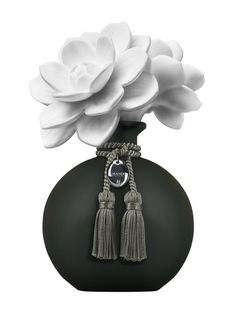 a black vase with white flowers in it