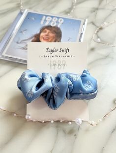 a blue hair scrunch on top of a white table next to a card