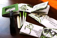 several green and white business cards sitting on top of a table next to a pen