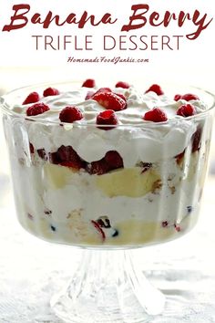 a trifle with strawberries and whipped cream in a glass dish on a table