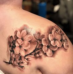 a woman's stomach with flowers on it and the back of her body covered in tattoos