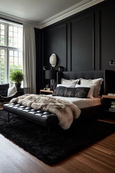 a bedroom with black walls and wood flooring has a fur rug on the bed