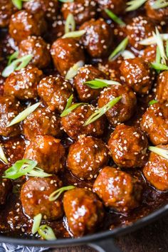 the meatballs are covered in sauce and garnished with green onions