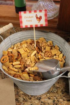 a bowl full of cheesy cereal with a spoon in it next to a sign that says chicken feed