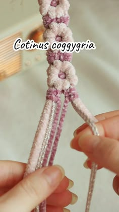 two hands are holding the ends of a crocheted piece with yarn on it