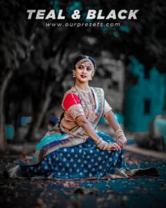 a woman sitting on the ground in a blue dress