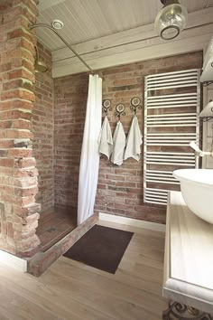 a bathroom with brick walls and wooden floors