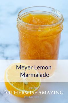 a jar filled with lemon marmalade next to an orange slice