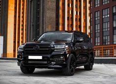 a black suv parked in front of a tall building