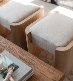 two wooden chairs sitting next to each other on top of a table