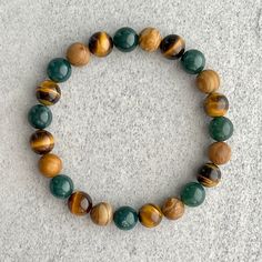 ~ 8mm moss agate beads ~ 8mm yellow tiger eye beads ~ 8mm wood jasper beads ~ Stretchy cord; simply slide bracelet on and off wrist ~ Comes packaged in a re-usable microfibre pouch To ensure the perfect fit, please use the bracelet sizing instructions found in the photo gallery. Cheap Wooden Bead Bracelets For Gifts, Cheap Wooden Beads Bracelet, Cheap Agate Beaded Bracelets, Yellow Beaded Bracelets, Jasper Bead Bracelet, Stretchy Beaded Bracelet, Slide Bracelet, Wood Bead Bracelet, Jasper Bracelet