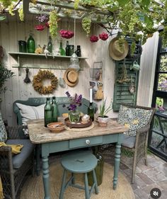 a table and chairs in a room with plants on the wall behind it, surrounded by potted plants