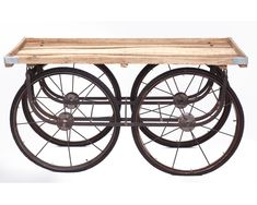 an old fashioned wooden cart with wheels on it's sides and metal rims