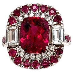 This Unique, One-of-a-Kind Custom-Made Ring is a masterpiece of luxury and sophistication, crafted in 14k white gold. The centerpiece of this ring is a finely faceted rubellite tourmaline, a vibrant stone known for its deep red-pink hue, flanked by two brilliant white sapphires on each side. Surrounding this exquisite combination is a halo of sparkling white diamonds, with additional red rubies set elegantly down the shank for added depth and color contrast. With a total carat weight (TCW) of 5. Ruby Jewel, Sparkling Jewelry, Diamonds And Pearls, Alberto Giacometti, Alumni Association, Ruby Diamond Rings, Jewels Rings, Golden Ring, Tourmaline Jewelry