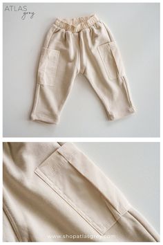 A pair of beige toddler pants with an elastic waistband and two square patch pockets on the sides, displayed on a flat, neutral surface.