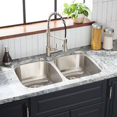 a kitchen sink with two faucets in it