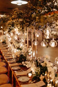 a long table with candles and flowers on it is set up for a formal function