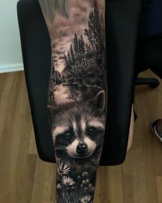 a man's arm with a raccoon and flowers tattoo on the forearm