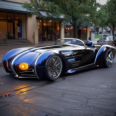 a blue and black sports car parked in front of a building