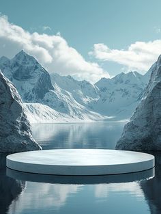 a large round pool surrounded by mountains and blue water in the middle of winter time