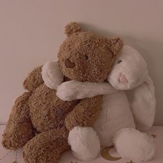 a brown and white teddy bear hugging each other