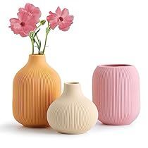 three vases with pink flowers in them on a white background, one is empty