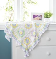 a crocheted blanket on top of a dresser