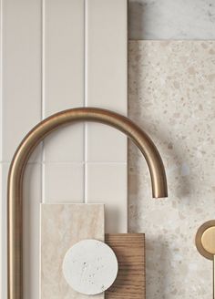 a gold faucet and soap dispenser in a white tiled bathroom