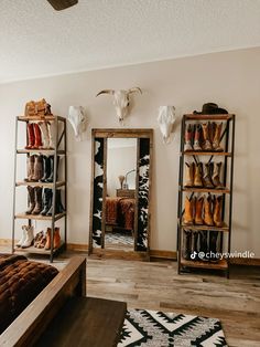 a bedroom with a bed, mirror and cow head on the wall