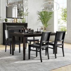 a dining room table and chairs in front of a large window with potted plants